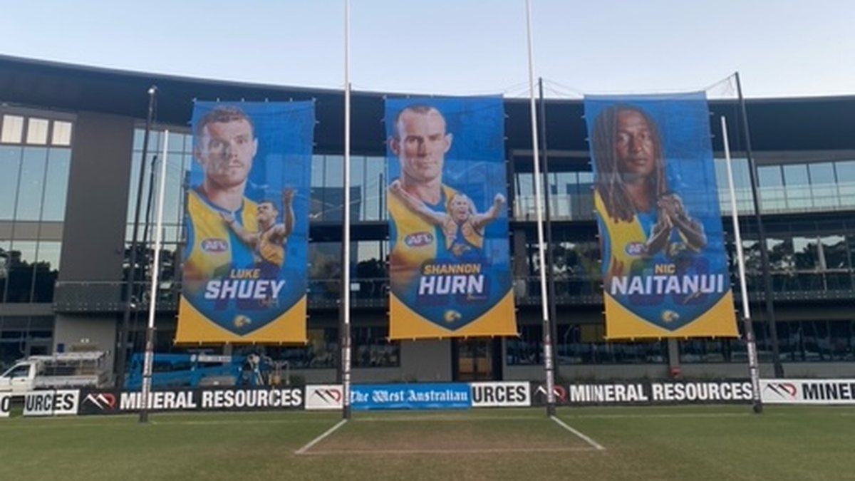 Printed player banners installed on flag poles outside a Perth stadium