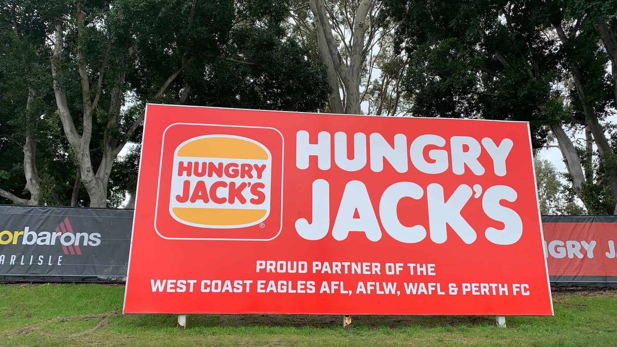 Large printed rigid sponsor board installed on a Perth sporting ground