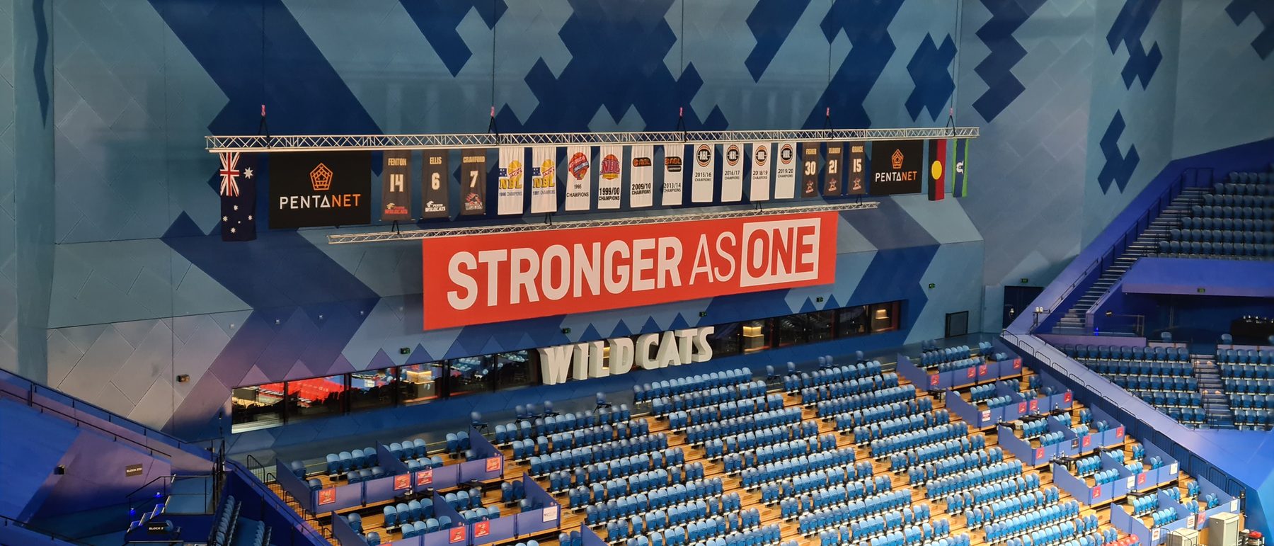Printed championship banners and arena signage installed at a Perth stadium